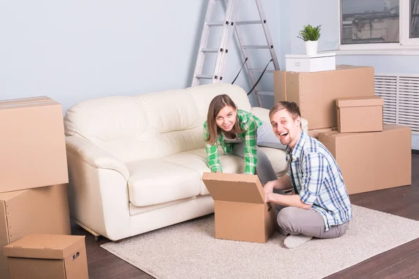 Umzug, neues Zuhause und Immobilienkonzept - junges Paar zieht gemeinsam in die neue Wohnung — Stockfoto