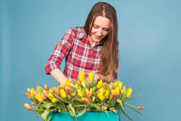 Kadın çiçekçi sıralar Lale kutusunun dışarı büyüleyici seçer onları için gelecekteki çiçek düzenleme