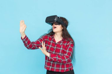 Gelecekte, teknoloji ve insan kavramı - vr-gözlüklü mavi arka plan üzerinde şaşırtıcı genç kadın