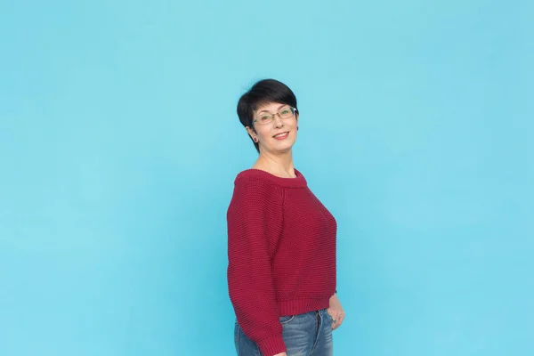 Koncepcja moda, ludzi i styl - połowy wieku Kobieta w crimson sweter na niebieskim tle z miejsca kopii — Zdjęcie stockowe