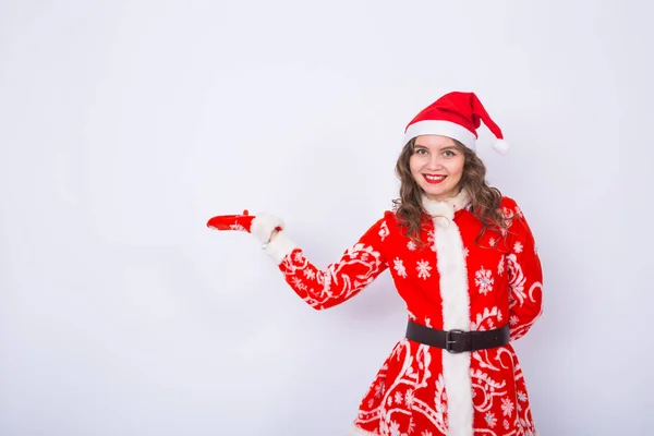 Noël, vacances et concept de personnes - la femme est costume de Père Noël pointant vers fond blanc avec espace de copie — Photo