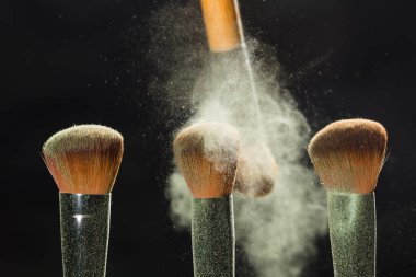 Güzellik ve mineral toz kavramı - oluşturan kozmetik fırça ve patlama renkli makyaj toz arka plan