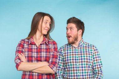 Komik genç çift gülüyor ve birlikte üzerinde mavi arka plan dalga geçmeyi.