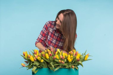 Kadın çiçekçi sıralar Lale kutusunun dışarı büyüleyici seçer onları için gelecekteki çiçek düzenleme