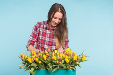 Kadın çiçekçi sıralar Lale kutusunun dışarı büyüleyici seçer onları için gelecekteki çiçek düzenleme
