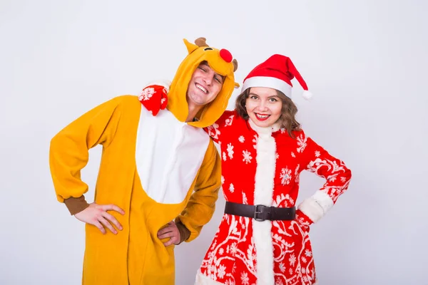 Szczęśliwa młoda kobieta w santa claus kapelusz i człowiek w karnawał kostium jeleni. Koncepcja zabawy, wakacje, żart i Boże Narodzenie — Zdjęcie stockowe