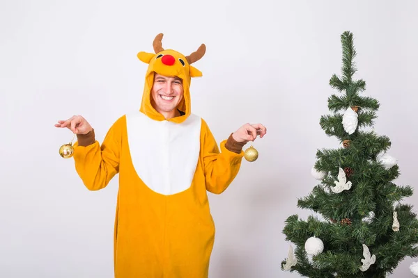 Skämt, jul, folk koncept - mannen i rådjur kostym dekorera xmas träd på vit bakgrund — Stockfoto