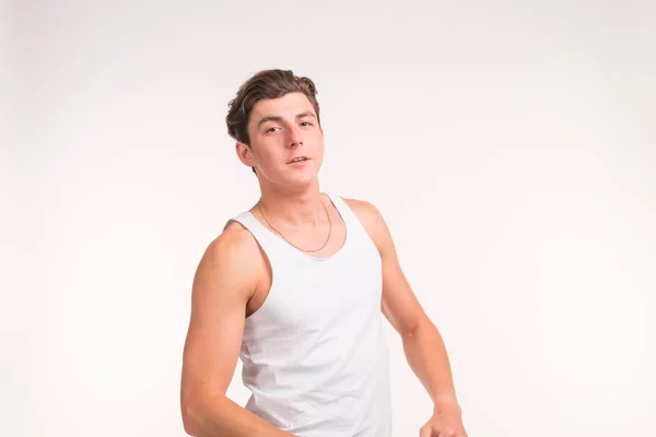 Люди и спортивная концепция - молодой уверенный в себе мускулистый человек на белом фоне — стоковое фото