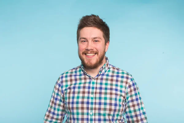 Retrato de cerca del hombre guapo barbudo sobre fondo azul — Foto de Stock