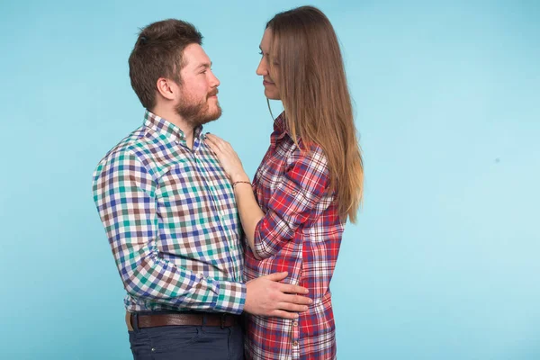 Retrato de alegre rindo jovens amantes engraçados brincando no fundo azul — Fotografia de Stock