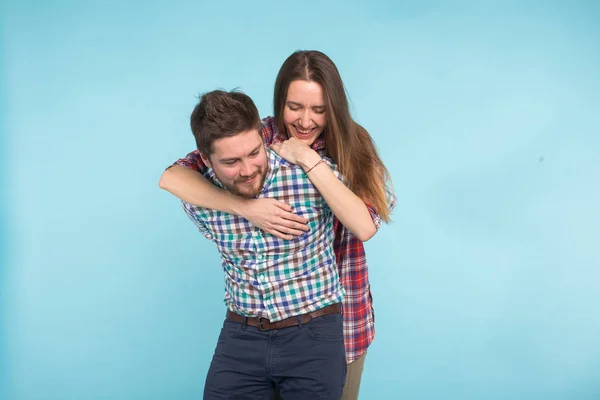 Retrato de alegre rindo jovens amantes engraçados brincando no fundo azul — Fotografia de Stock