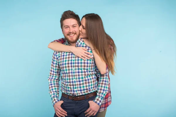 Retrato de risas alegres divertidos amantes jóvenes tonteando sobre fondo azul — Foto de Stock