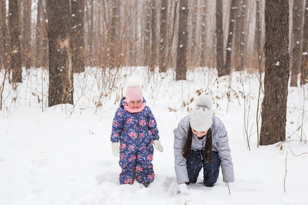 Οικογένεια, παιδιά και φύση έννοια - μητέρα με την κόρη να διασκεδάσουν στο πάρκο χειμώνα — Φωτογραφία Αρχείου