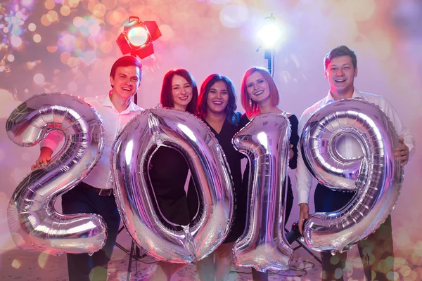 Festa, feriados e conceito de pessoas - Grupo de amigos celebrando Ano Novo segurando grande símbolo 2019 — Fotografia de Stock