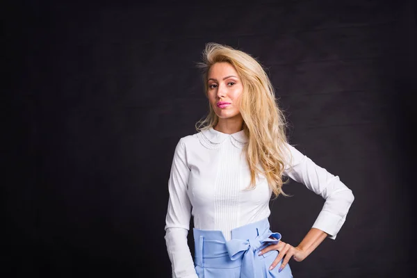 Mode-, portret- en mensen concept - jonge blonde vrouw boven de zwarte achtergrond met kopie ruimte staan — Stockfoto