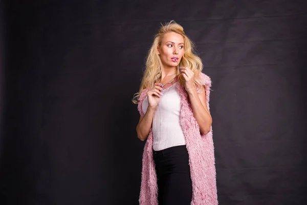 时尚和美容概念-粉红色羊毛衫的金发模特肖像摆在黑暗背景与复制空间 — 图库照片