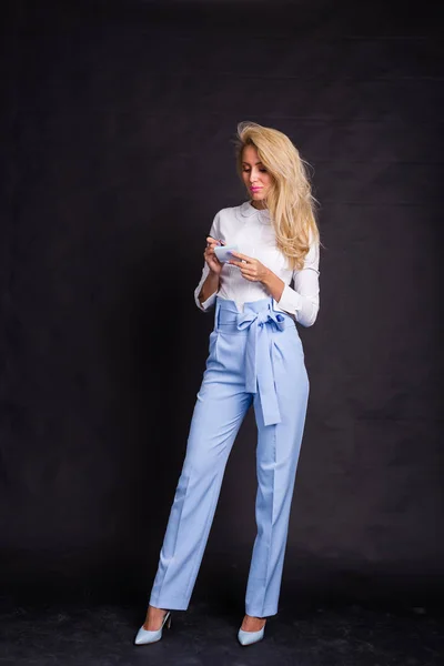 Conceito de moda, negócios e pessoas - Mulher loira bonito em jeans escreve notas sobre adesivos sobre fundo preto — Fotografia de Stock