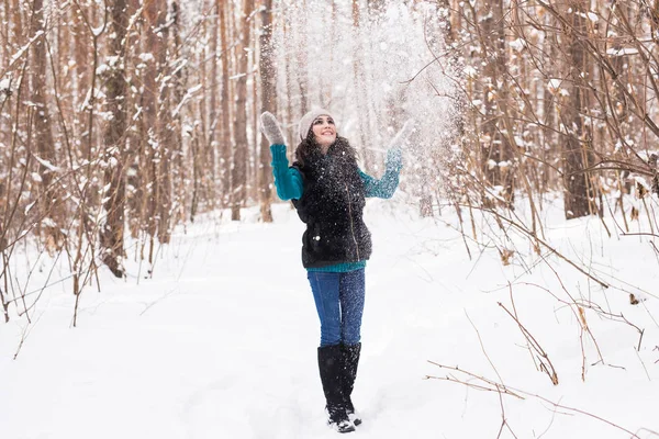 Jovem feliz brinca com uma neve na floresta nevada ao ar livre — Fotografia de Stock