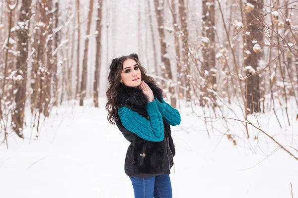 Fiatal, csinos nő séta a téli havas parkban a napsütéses napon — Stock Fotó