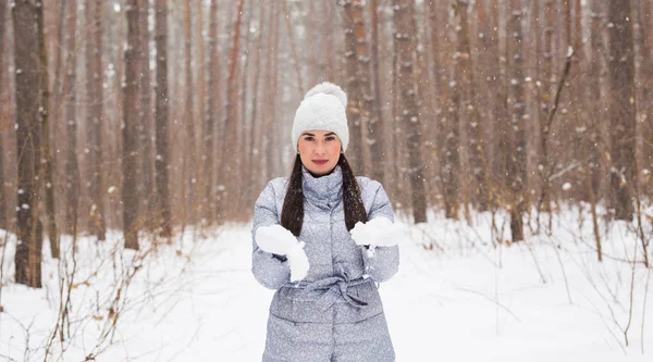 Inverno, vacanze e concetto della gente - la giovane donna allegra è felice di camminare in foresta invernale con neve — Foto Stock