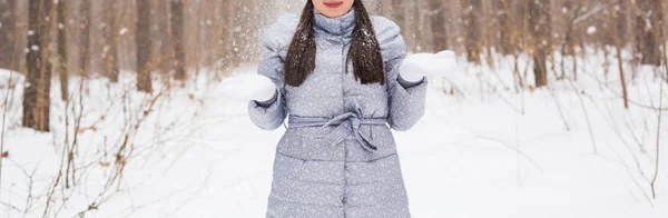 Invierno, temporada y concepto de personas - Primer plano de la mujer en abrigo gris caminando en el parque de invierno y jugando con la nieve — Foto de Stock