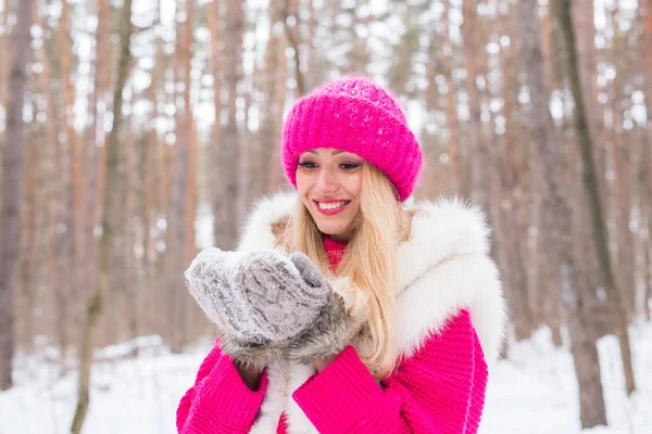 Noël, vacances et concept de saison - Jeune belle femme souriante tenant la neige dans les mains en hiver à l'extérieur — Photo