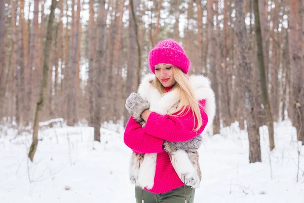 Мода і концепція людей - приваблива молода жінка, що стоїть в рожевій теплій куртці в зимовому сніжному парку — стокове фото