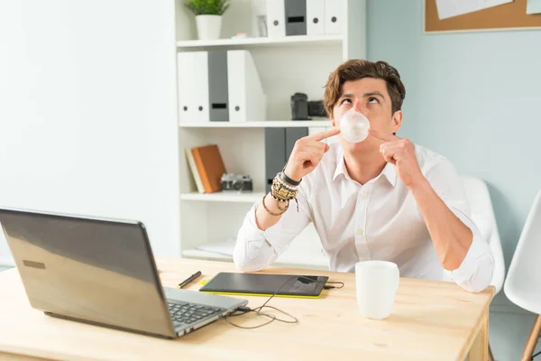 Joke, office, humor, people concept - handsome man chewing gum and thinking about something, huge bubble