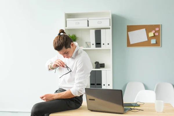 Persone, divertimento e business concept: il giovane uomo d'affari pulisce i suoi occhiali con la camicia — Foto Stock