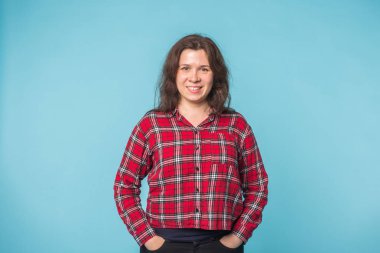 Duygu ve insanlar kavramı - neşeli genç kadın kopya alanı ile mavi arka plan üzerinde gülümseyen