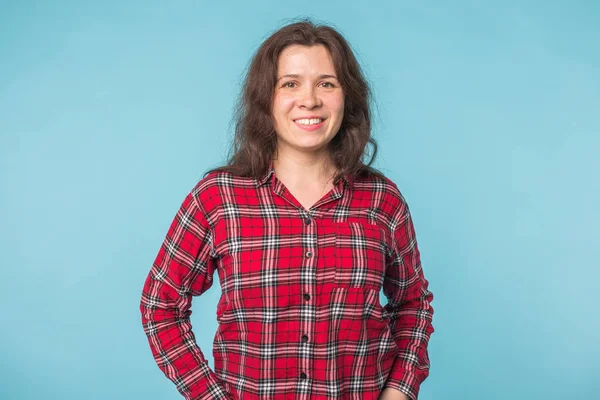 Conceito de emoções e pessoas - Jovem atraente sorrindo sobre fundo azul com espaço de cópia — Fotografia de Stock