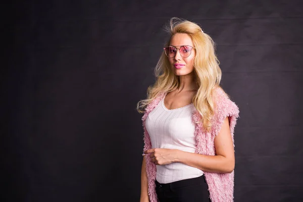 Mode en beauty concept - portret van blond model gekleed in een wit overhemd en roze vest op zwarte achtergrond met kopie ruimte — Stockfoto