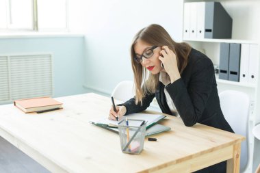Office, iş ve insan kavramı - cep telefonu ve ofisinde bir masa üzerine not almak: çağrı mutlu iş kadını