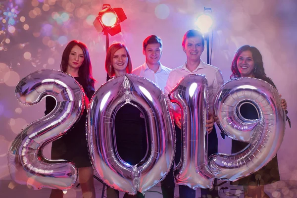 Festa, feriados e conceito de pessoas - Grupo de amigos celebrando Ano Novo segurando grande símbolo 2019 — Fotografia de Stock