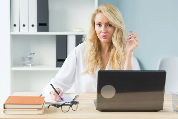 Business, technologie et concept de personnes - jeune femme blonde travaillant dans un ordinateur portable et souriant — Photo