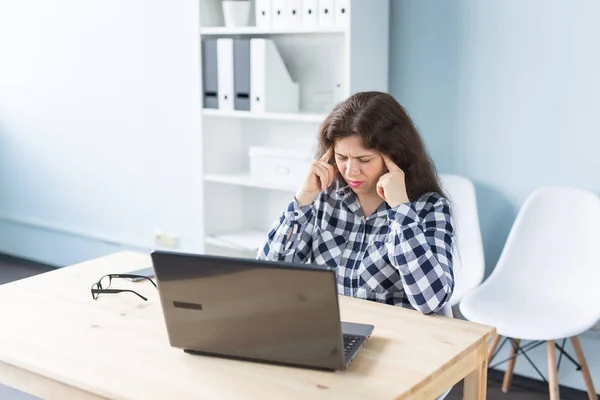 Giovane donna ha mal di testa mentre lavora sul computer portatile in ufficio — Foto Stock