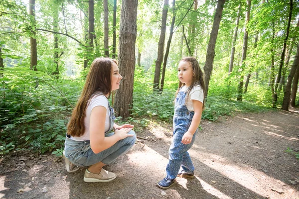 Naturaleza, maternidad y concepto de niño - Madre feliz e hija pequeña se divierten en el parque verde —  Fotos de Stock