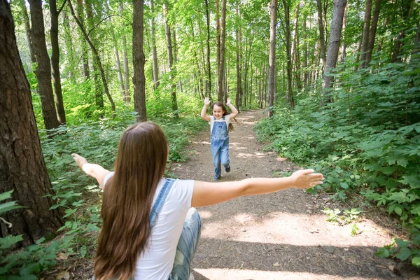 自然, 家庭, 人的概念-可爱的小女孩和年轻女子在美丽的森林。女儿跑到母亲 — 图库照片