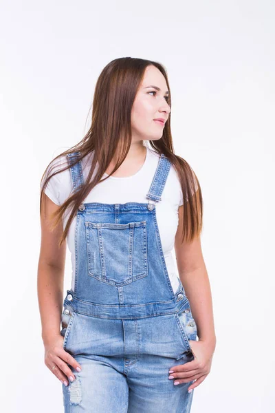 Portrait of a smiling pretty woman in denim overall isolated on white background — Stock Photo, Image