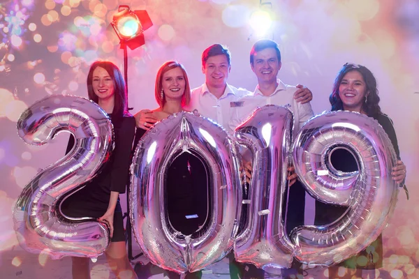 Festa, pessoas e conceito de feriados de ano novo - mulheres e homens celebrando véspera de ano novo 2019 — Fotografia de Stock