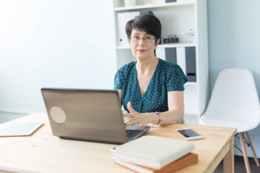 İş insan ve teknoloji kavramı - laptop çalışan orta yaşlı kadın