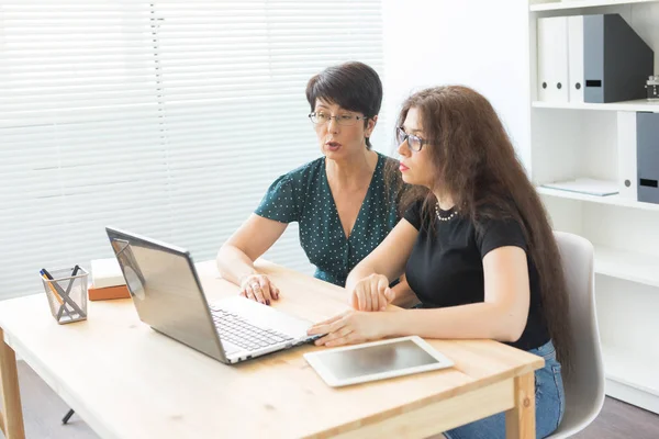 Büro, Geschäftsleute und Grafikdesign-Konzept - Frauen sitzen mit Laptop im Büro und diskutieren Ideen, schauen auf den Bildschirm, hören Meinungen — Stockfoto