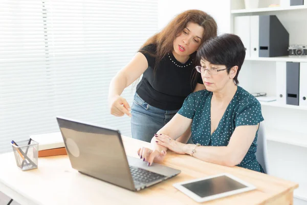 Geschäftsleute und Grafikdesignerkonzept - Frauen diskutieren Ideen im Büro mit Laptop und zeigen auf den Bildschirm — Stockfoto