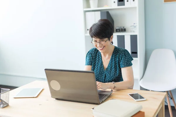 Business people and technology concept - La donna di mezza età sta lavorando in ufficio con il laptop — Foto Stock