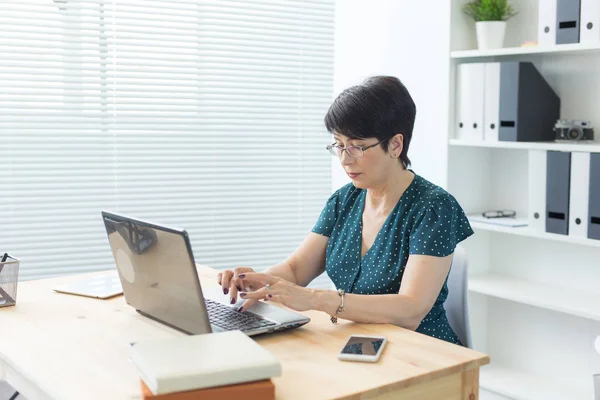 Business, People and Technology Konzept - Frau mittleren Alters mit Laptop zu Hause oder im Büro — Stockfoto