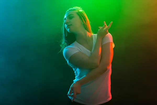 Tanec, sport a lidé koncept - Cheerleading dívka tančí na vícebarevné pozadí. — Stock fotografie