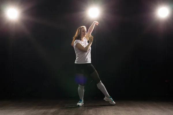 Gente y concepto de baile - Mujer joven bailando jazz funk sobre fondo oscuro — Foto de Stock