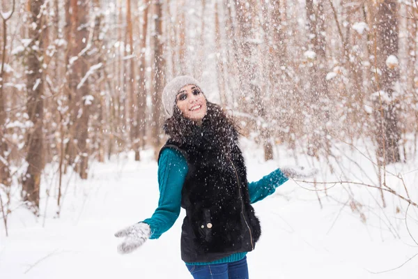 Сезон, дозвілля і концепція людей - молода жінка щаслива і кидає сніг в зимову природу — стокове фото