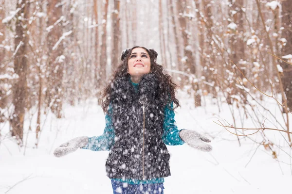 Retrato de uma jovem que atira a neve. Menina sorridente andando em um parque de inverno e se divertindo em um dia ensolarado frio ao ar livre — Fotografia de Stock