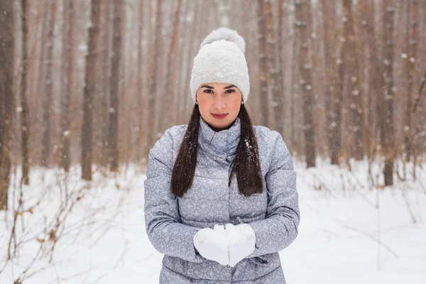 Walks, season and people concept - happy young woman holding snow in winter park — Stock Photo, Image
